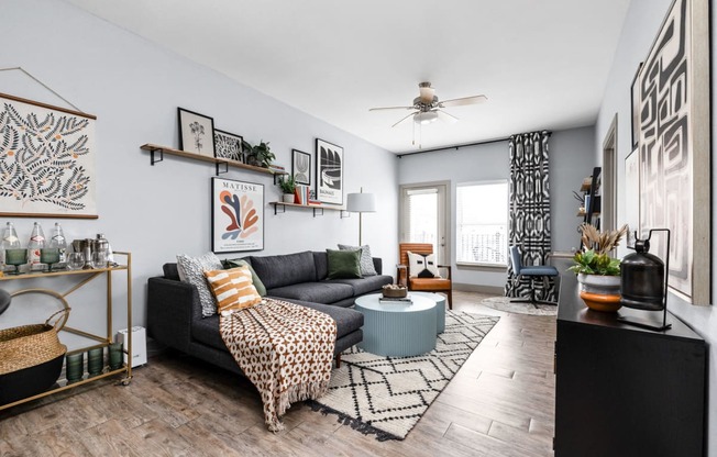 a living room with a couch and a coffee table and a ceiling fan