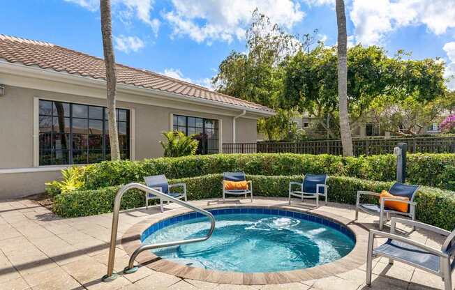 A small pool in a backyard with a house in the background.