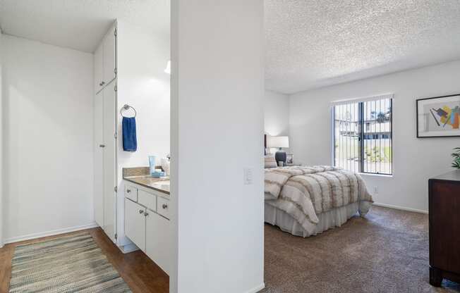a bedroom with a bed and a sink and a window