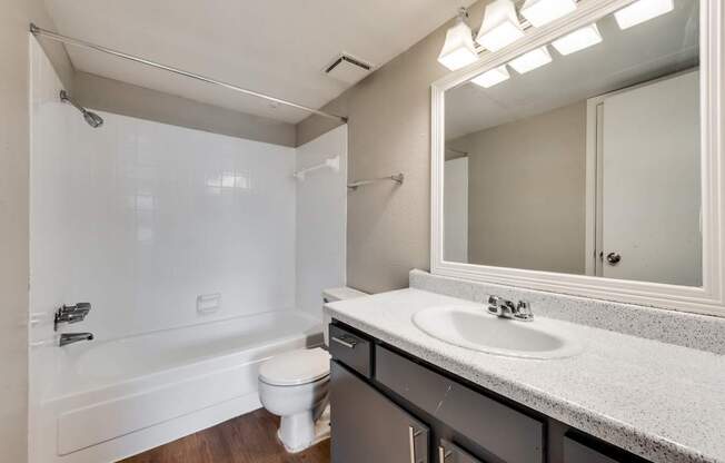 A white bathroom with a sink, toilet, and bathtub.