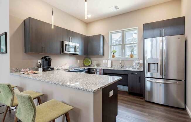 A kitchen with a granite countertop and stainless steel appliances.