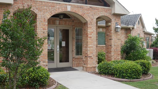 A brick building with a glass door and window.
