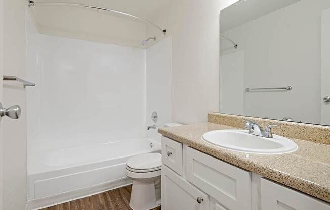A white bathroom with a toilet, sink, and bathtub.