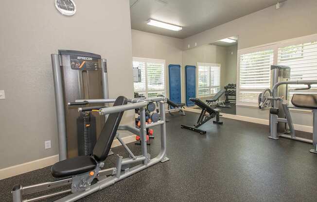 A gym with a variety of equipment including a leg press machine at Stoneridge Apartments, California, 95661