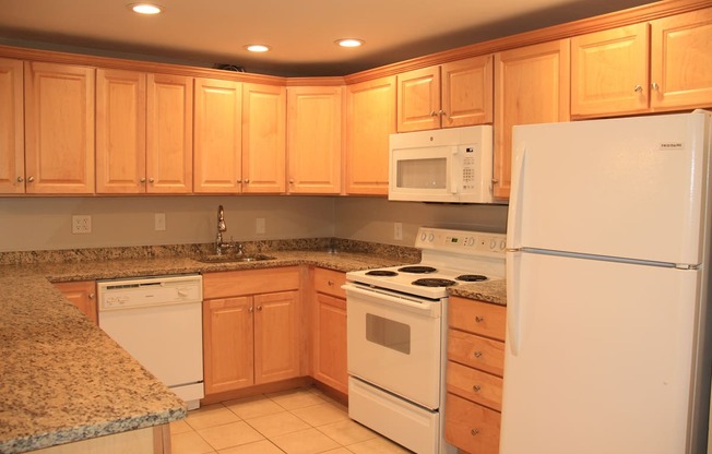 a kitchen with white appliances and granite counter topsat Renew Worcester, Worcester, MA