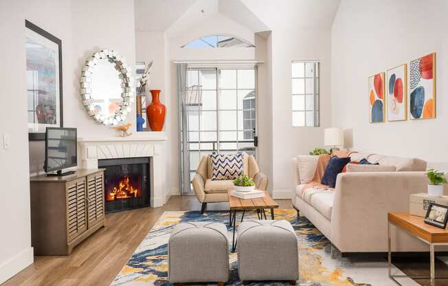 Pet-Friendly Apartments In Los Angeles, CA - The Preston Miracle Mile - Living Room With High Ceilings, Plank Wood Style Flooring, Gas Fireplace, And A Private Patio or Balcony