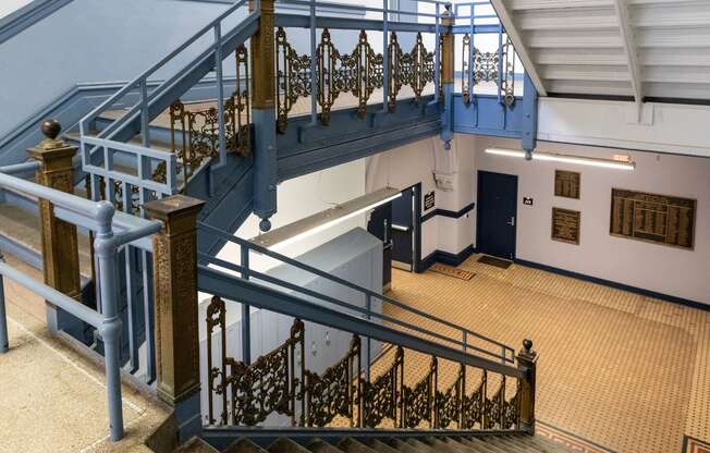 a staircase in a building with blue railing and stairs at Residences at South High, Pittsburgh, PA 15203 ? 