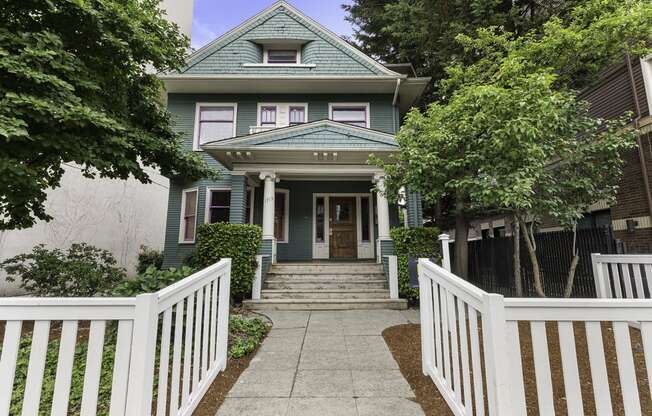a house with a white fence in front of it  at Charbern Apartment Homes, Seattle, 98122