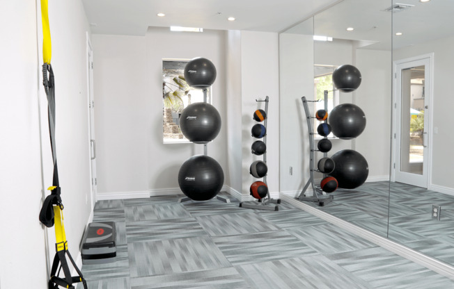 A room with a grey carpet and a yellow exercise equipment.