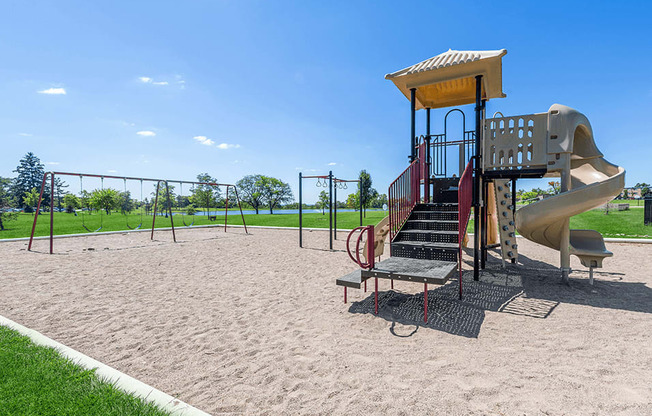 a playground with a swing set and a slide in a park