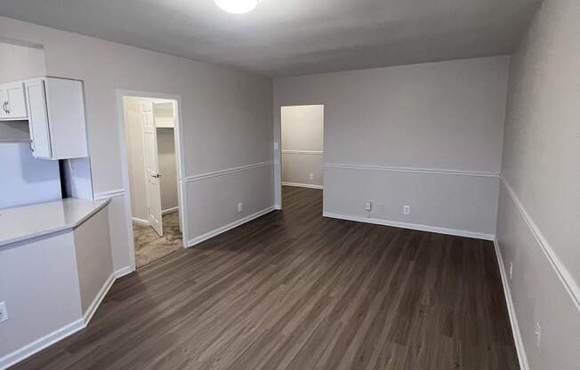 A room with wooden flooring and white walls.
