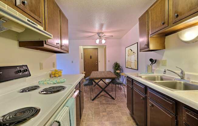 Fargo, ND Saddlebrook Apartments. a kitchen with a stove top oven next to a sink