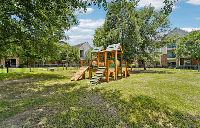 A playground with a wooden swing set and a green roof.