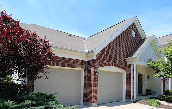 A house with a red brick facade and a white garage door.