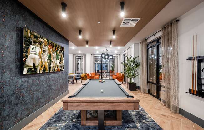 a game room with a pool table and a painting on the wall