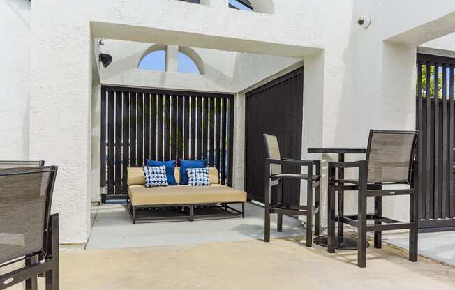 a patio with a couch and tables and chairs