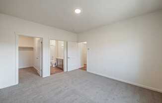 a living room with white walls and carpet and a door to a bathroom at Gateway Apartments, Washington