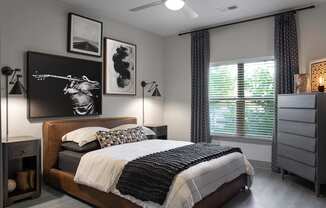 A bedroom with a large bed and a painting on the wall.