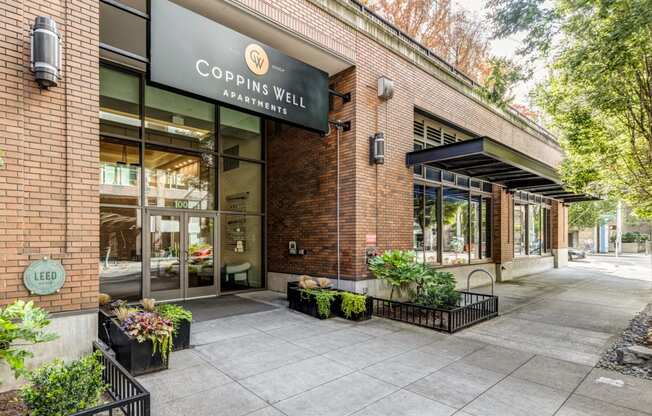 the facade of a building with a sign that reads Coppins Well Apartments