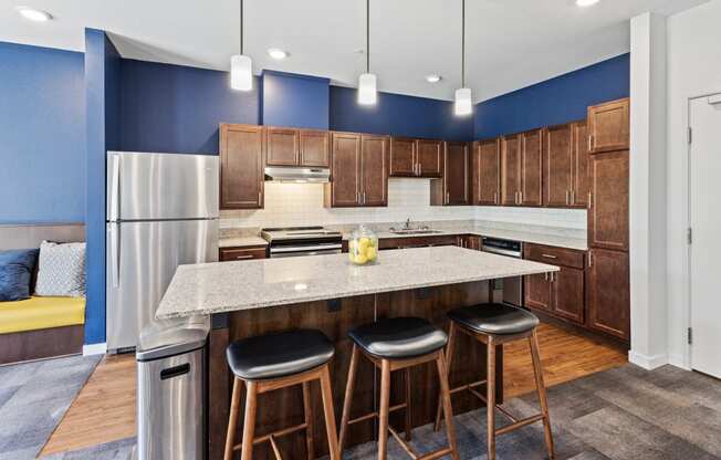 a kitchen with a large island with three stools