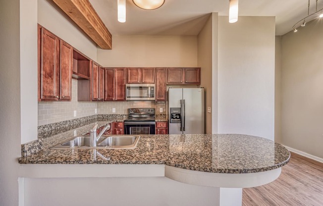 A kitchen with granite countertops and wooden cabinets  at The District, Denver, CO