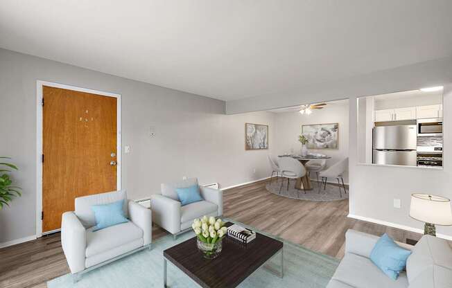 A living room with a brown door, a white couch, a coffee table, and a plant.