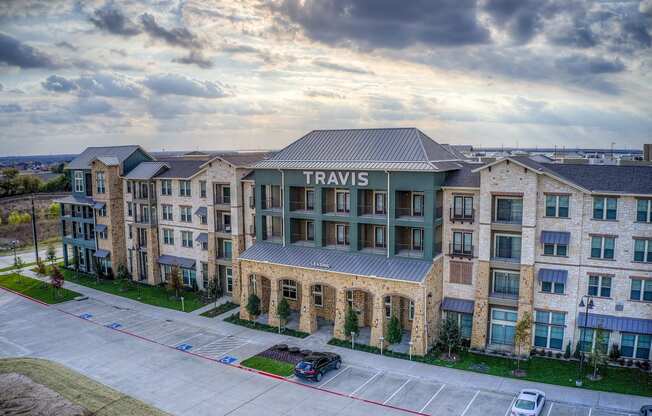 an aerial view of a large apartment building with a parking lot in front of it