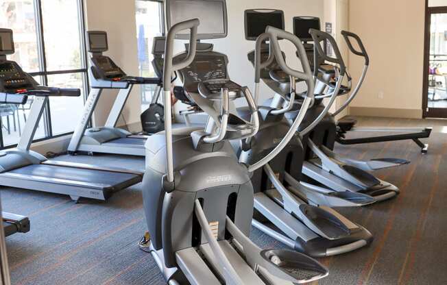 a row of exercise machines in a gym