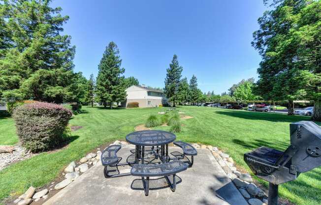 Community BBQ and Picnic Area with Black Table on concrete pad. at Monte Bello Apartments, Sacramento, CA, 95826
