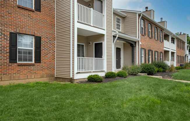 A row of townhouses with a green lawn in front.