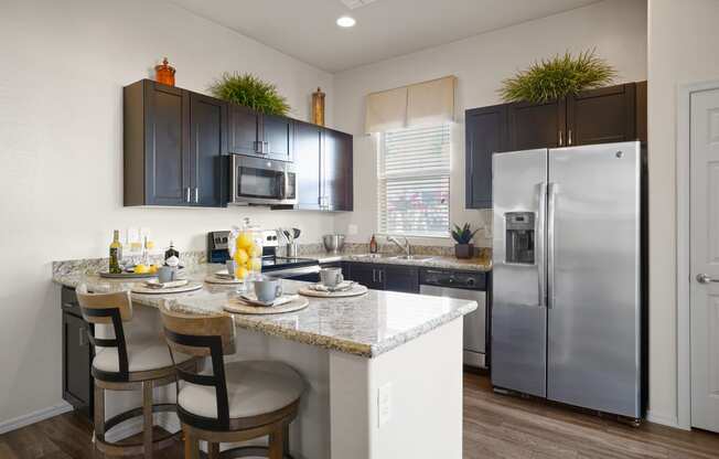 a kitchen with stainless steel appliances and a counter with bar stools