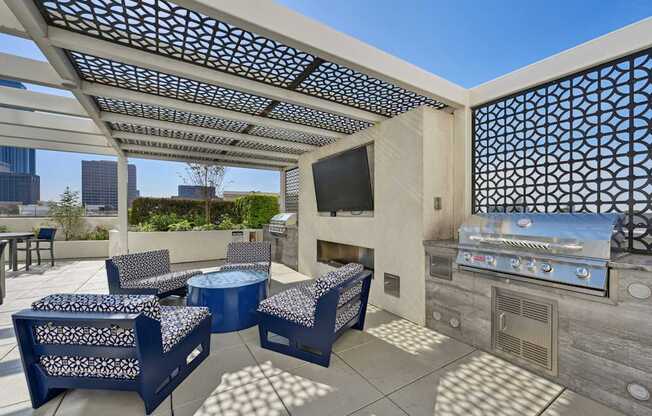 Outdoor grilling station with BBQ grill and seating at Dominion Post Oak apartments in Houston, TX