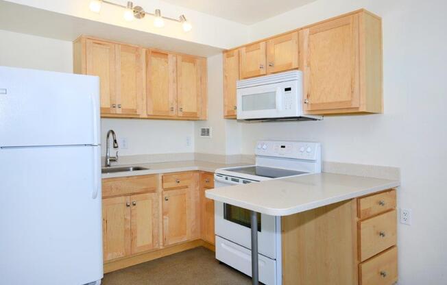 A kitchen with wooden cabinets and white appliances.