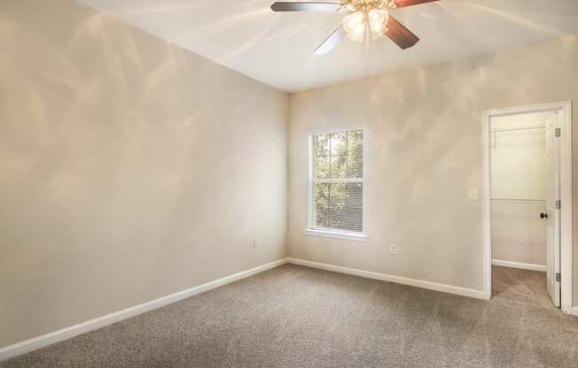 Bright empty bedroom with carpet floor and large windows at Angel Landing apartments in Pensacola, FL