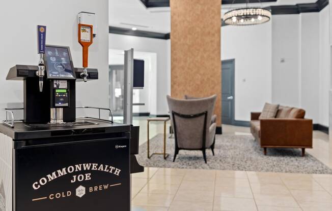 a coffee machine in the lobby of a hotel with a couch and chairs