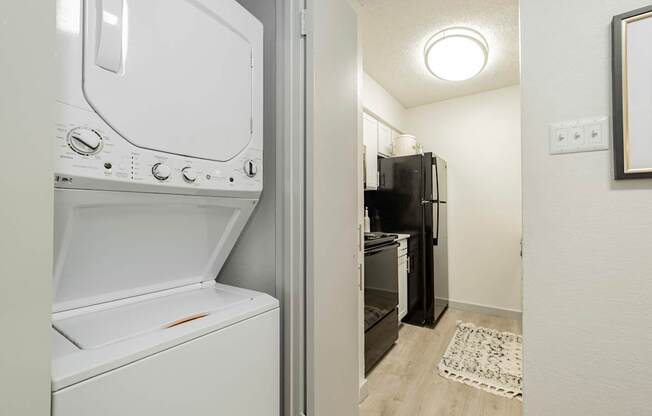 A white dishwasher is next to a black refrigerator in a small kitchen.