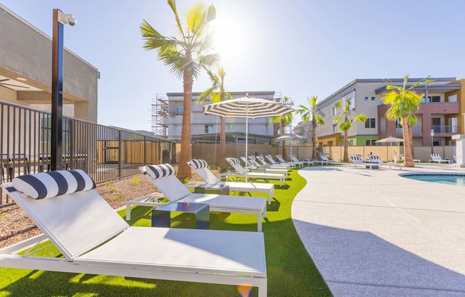 a row of lounge chairs next to a pool in a building