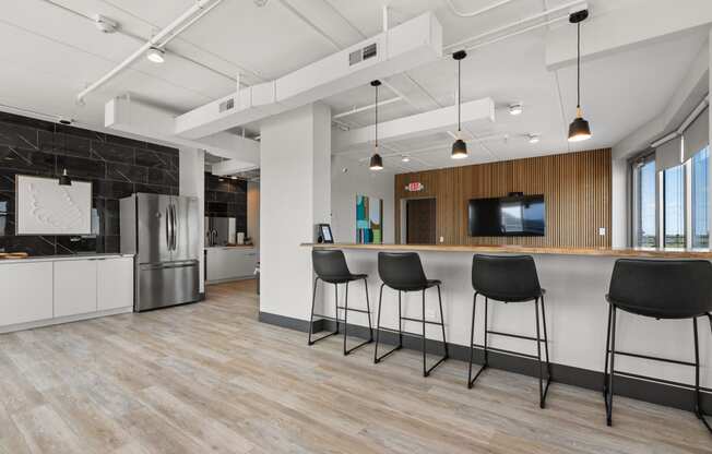 a kitchen and living room with a bar and chairs