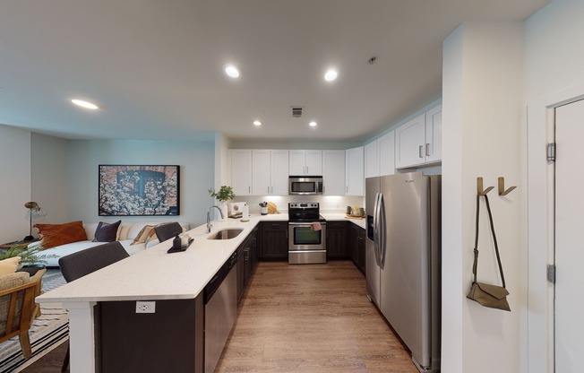 Open kitchen meticulously reimagined with two-tone cabinets, quartz counters, and stainless steel appliances
