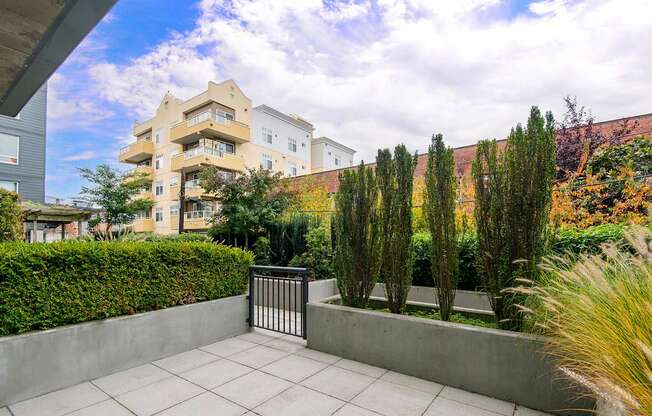 A patio with a black gate and a concrete floor.