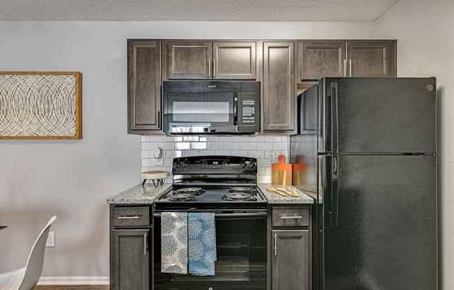 a kitchen with black appliances and wood cabinets