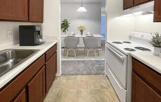 a kitchen with white appliances and a dining room with a table