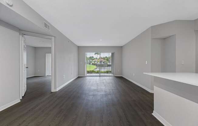 an empty living room with white walls and wood floors