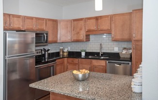 Upgraded kitchen with granite countertops, tile backsplash and stainless steel appliances