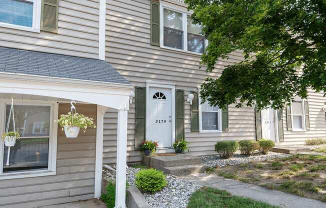 the front of a apartment building with a white door and a porch