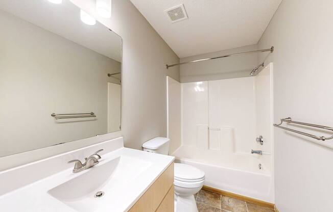 A bathroom with a white sink, toilet, and bathtub.