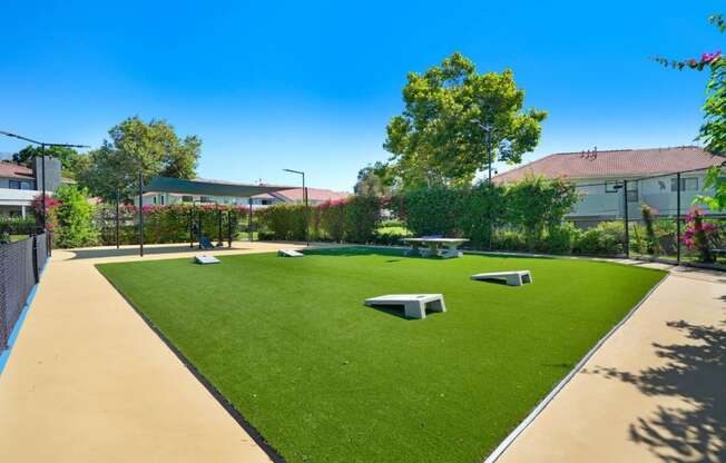 a grassy area with a picnic table and benches at The Park Apartments, California, 91730