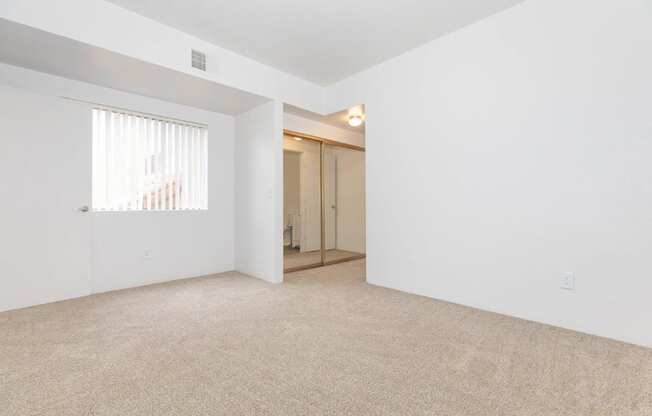 A room with a carpeted floor and a doorway leading to another room.