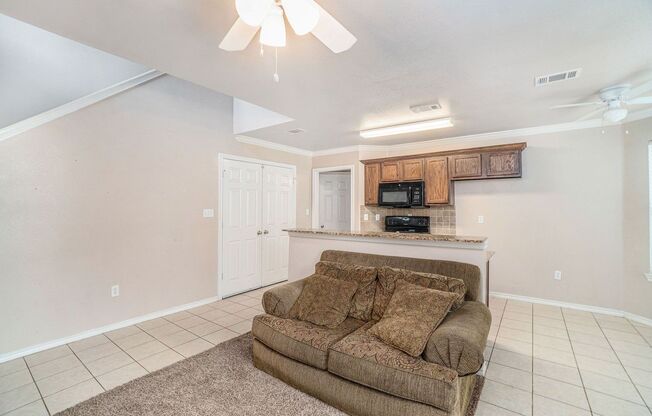 Beautiful two story townhome, crown molding, granite countertops, stained cabinets and carpeting in living area.