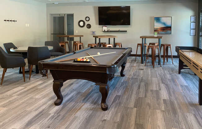 a games room with a pool table and a tv
